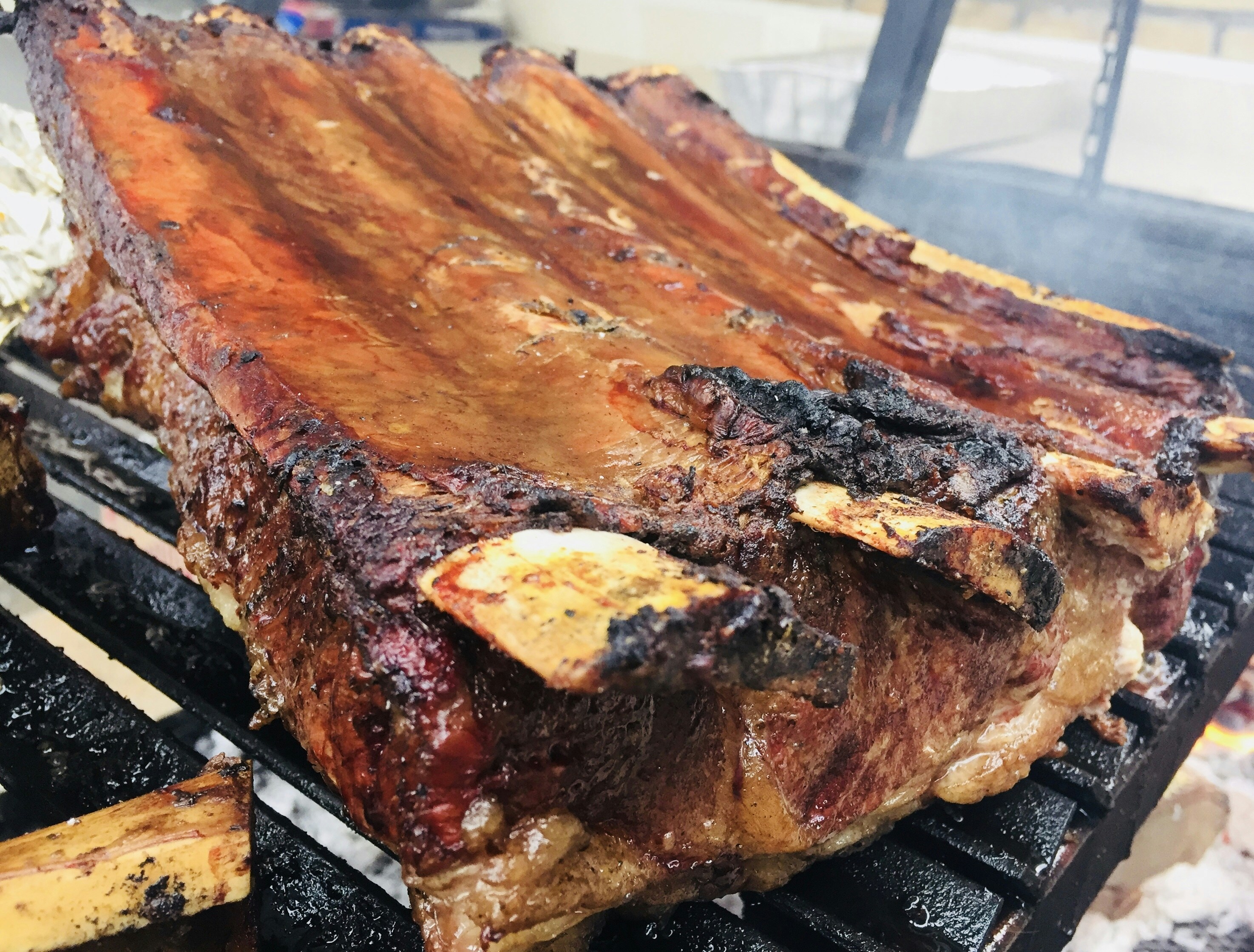 Marinated Korean beef short ribs galbi caramelizing on charcoal grill
