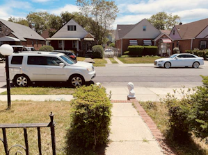 A residential neighborhood with well-maintained homes and a service van parked outside.