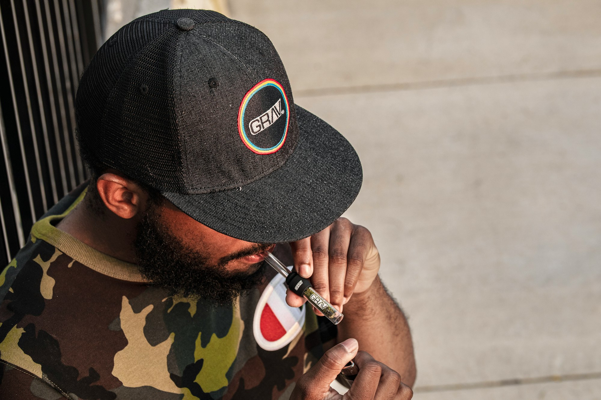 man in black and green camouflage hat holding black and white smartphone