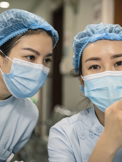 woman in white shirt wearing white mask holding iphone