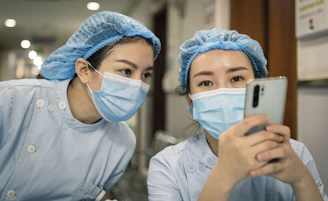 woman in white shirt wearing white mask holding iphone