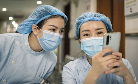 woman in white shirt wearing white mask holding iphone