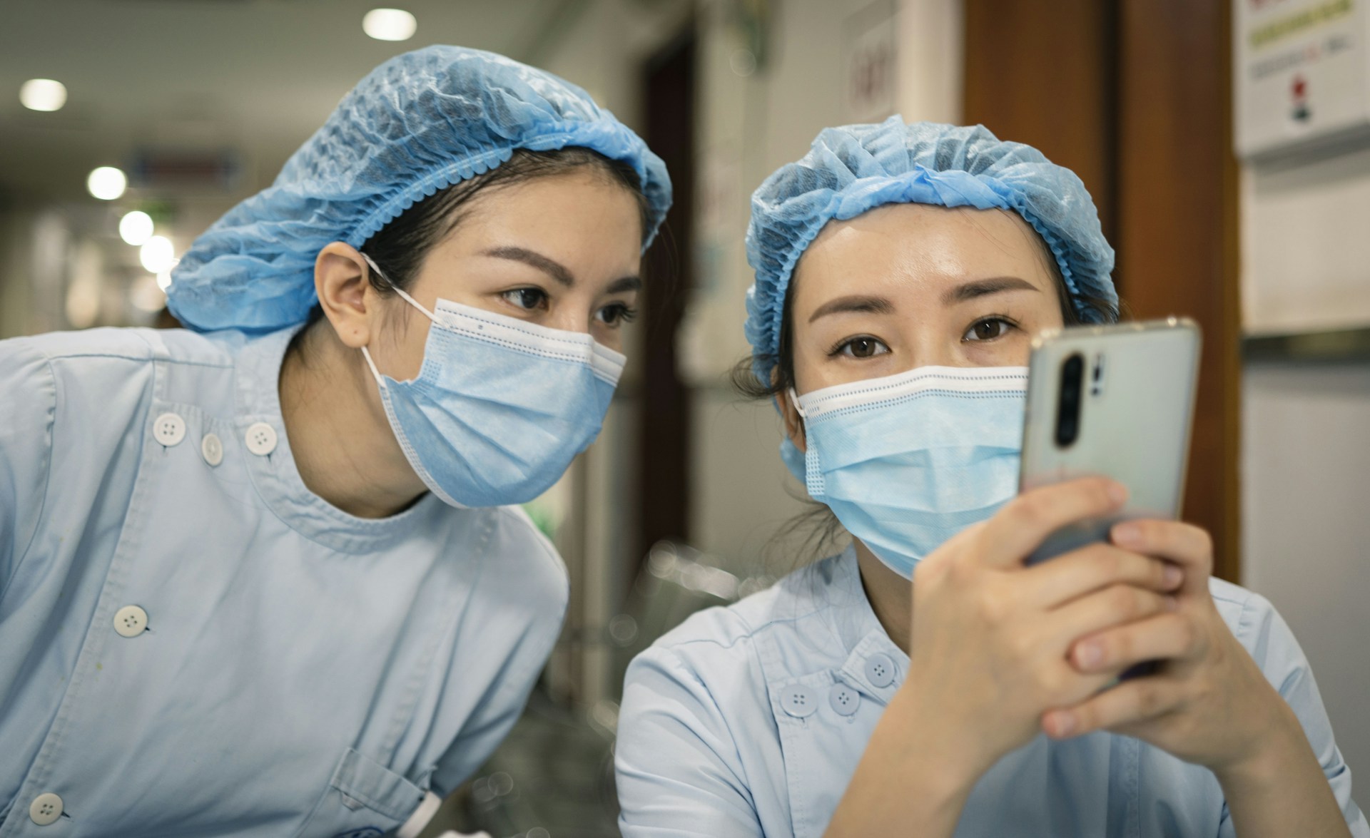 woman in white shirt wearing white mask holding iphone