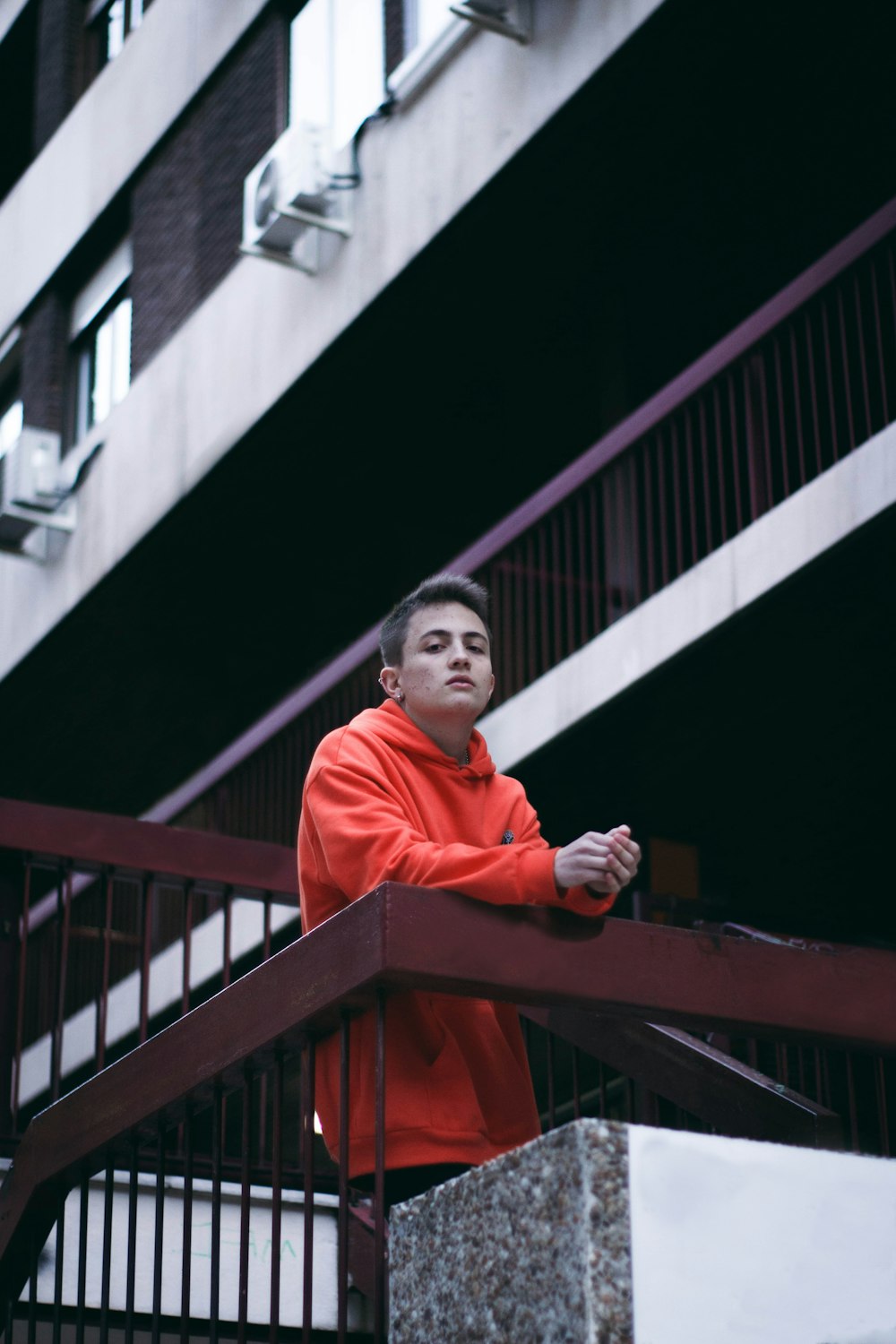 man in red jacket standing on stairs