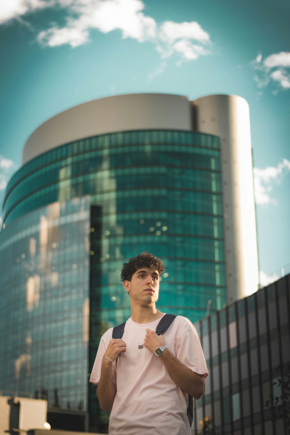 man in white polo shirt standing near building during daytime