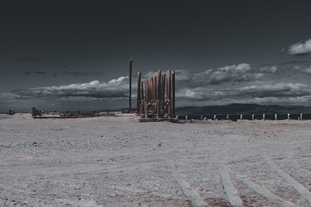 brown wooden post on brown sand under white clouds and blue sky during daytime