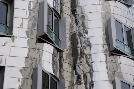 Close-up of a luxury building facade highlighting sleek silver and gold details.