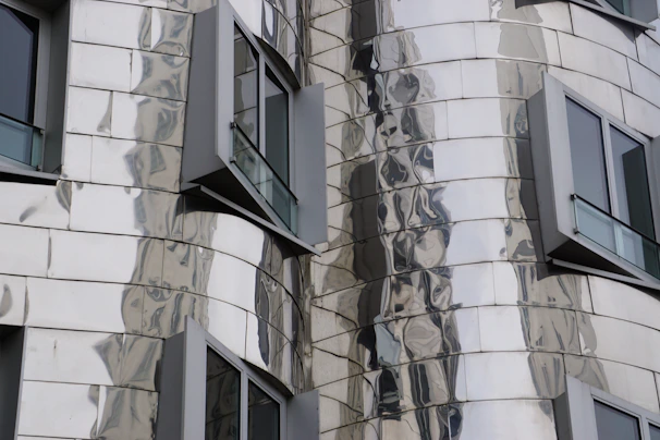 Close-up of a sleek aluminum façade panel reflecting sunlight on a modern building.
