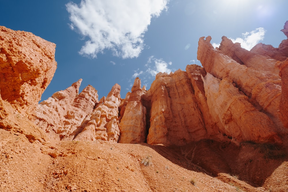 brown rock formation under blue sky and white clouds during daytime