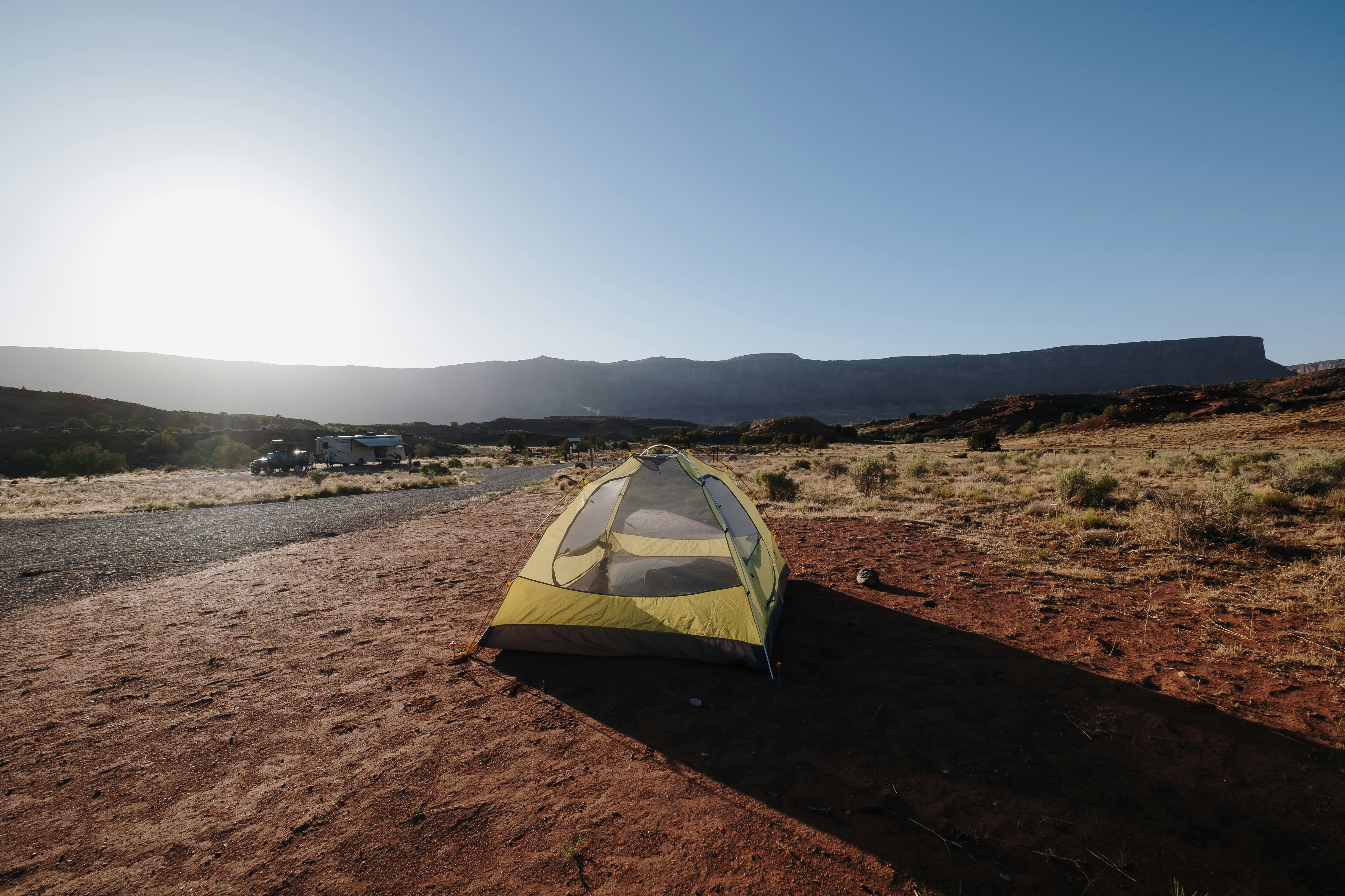 yellow and gray tent on brown sand under blue sky during daytime