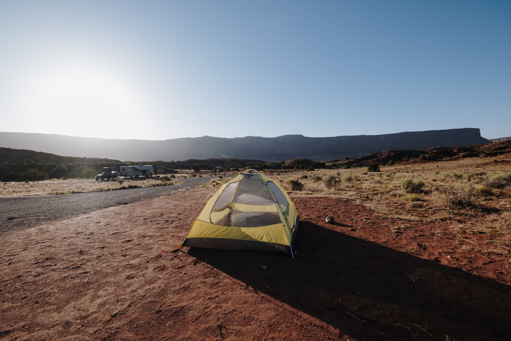 yellow and gray tent on brown sand under blue sky during daytime