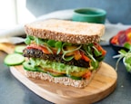 burger with lettuce and tomato on brown wooden chopping board