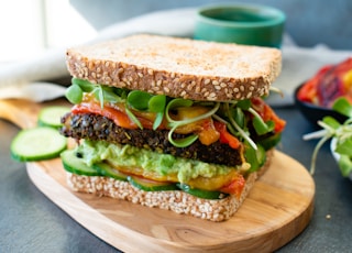 burger with lettuce and tomato on brown wooden chopping board