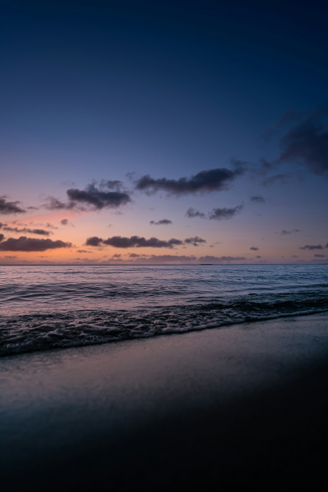 sea waves crashing on shore during sunset