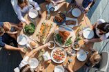 people eating on table with foods