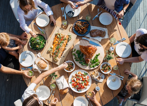 people eating on table with foods