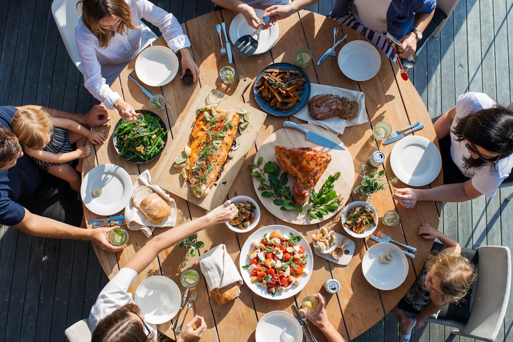 people eating on table with foods