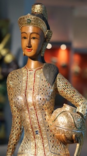 Elegant handcrafted wooden sculpture with gold leaf accents reflecting traditional Mexican craftsmanship.