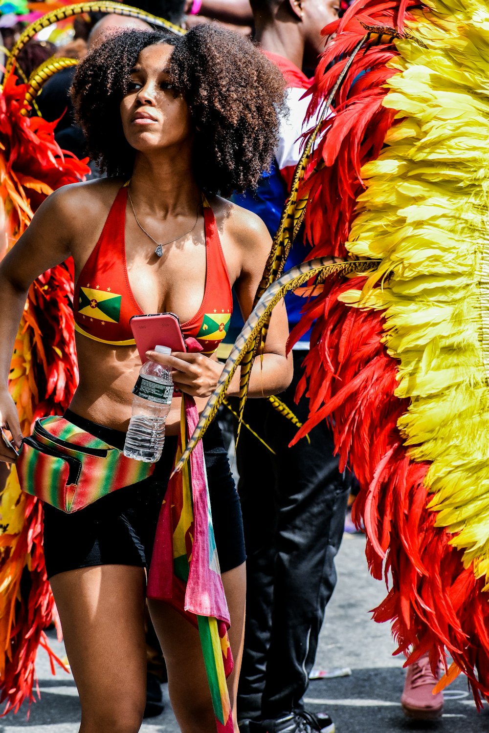 woman in red and yellow dress holding white bottle