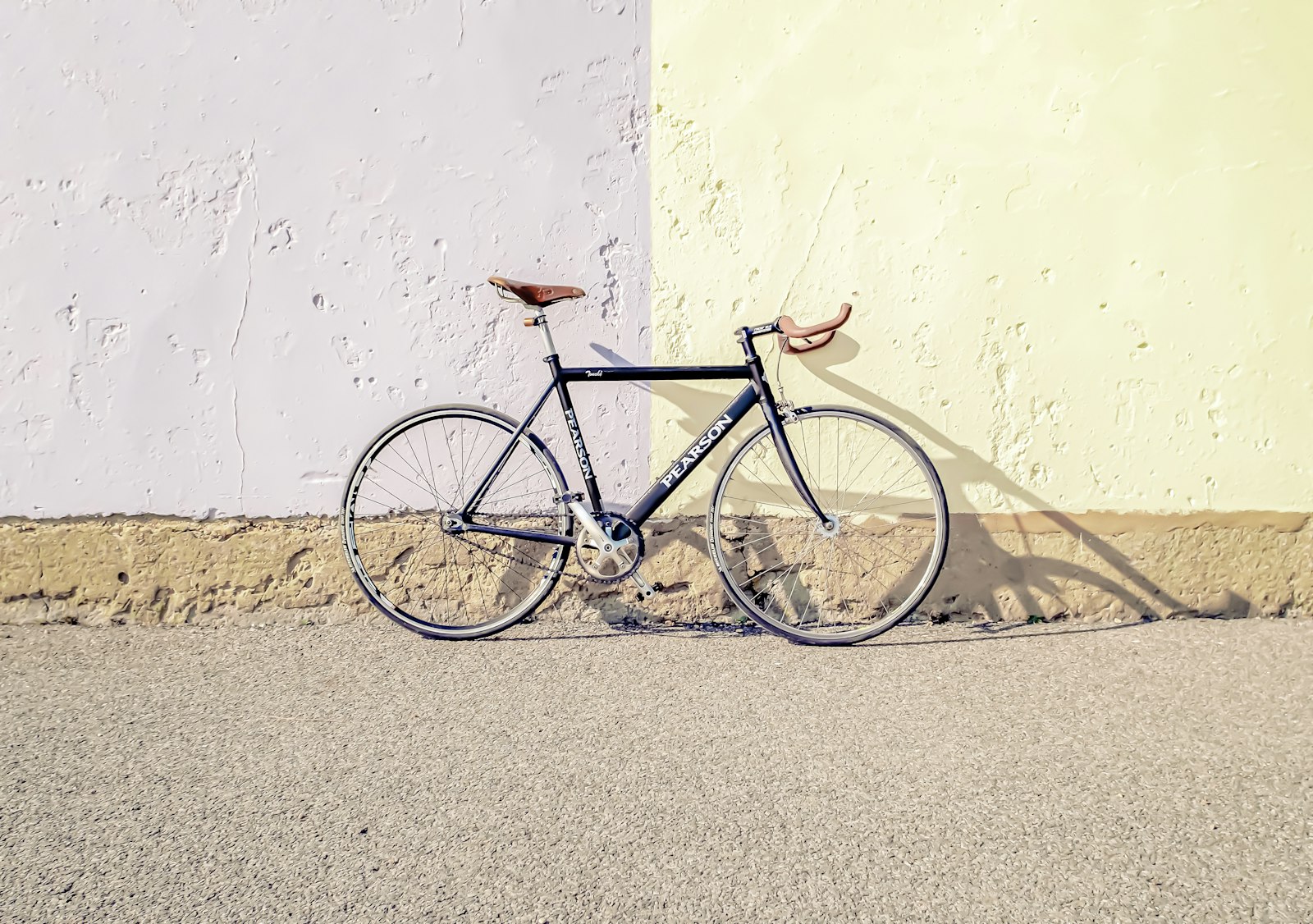 Bicycle resting by a freshly maintained outdoor courtyard and green verge
