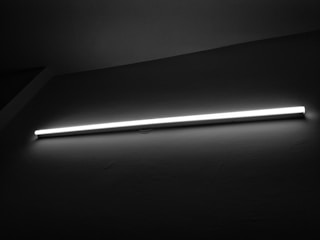 Bright LED tube lights illuminating a spacious warehouse.