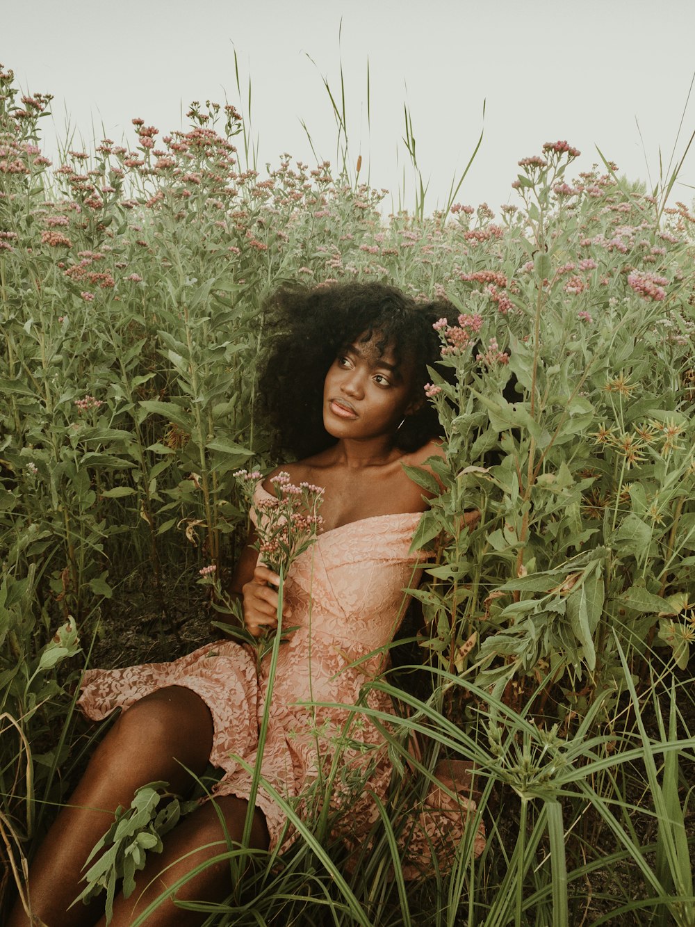 woman in brown dress sitting on green grass field