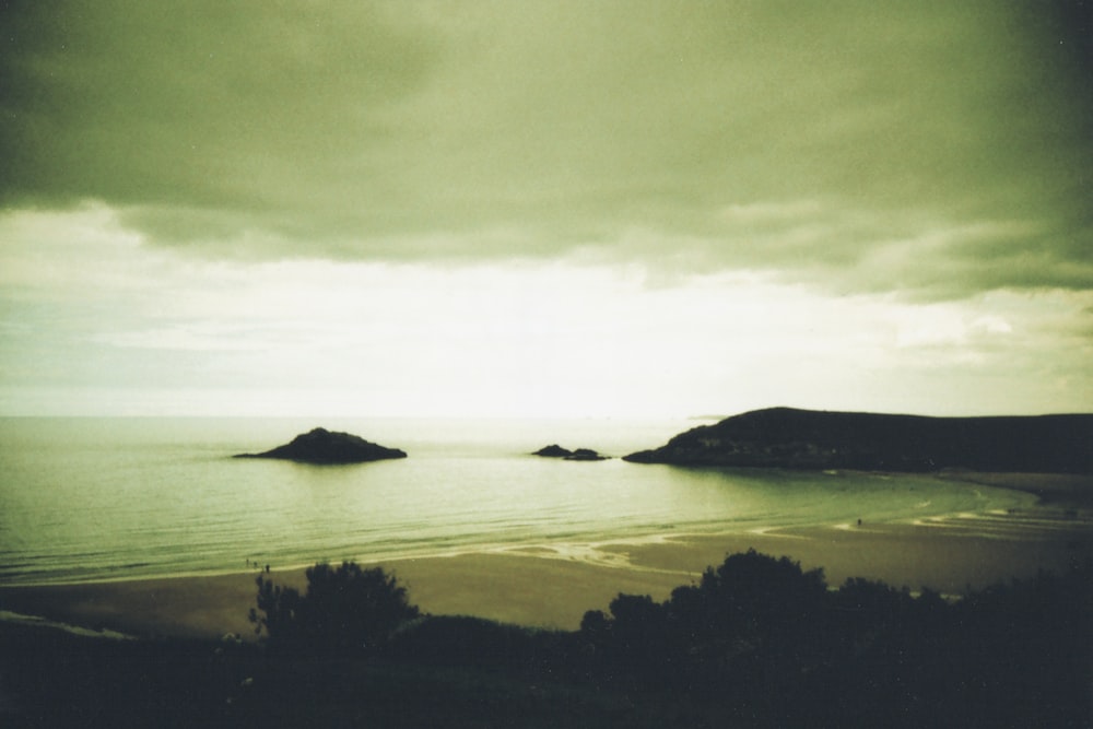 body of water near mountain during daytime