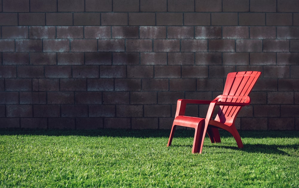 sillón de plástico rojo sobre campo de hierba verde