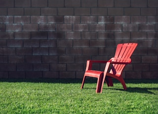 red plastic armchair on green grass field