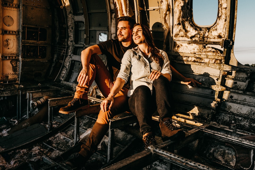 man and woman sitting on train rail during daytime