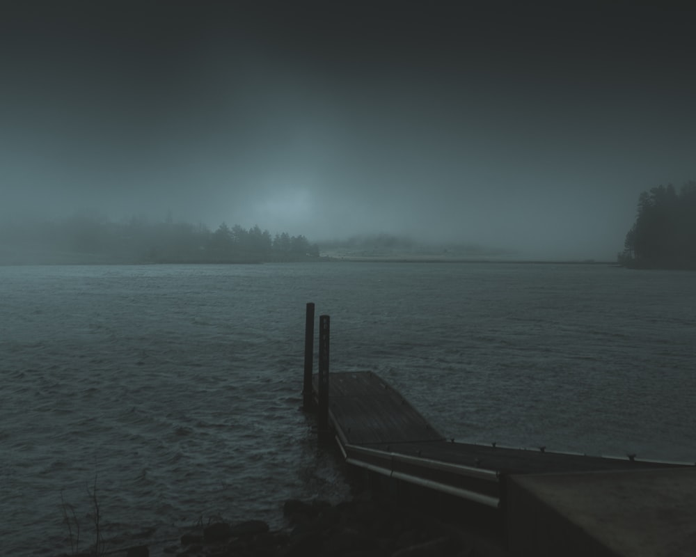 brown wooden dock on body of water during daytime