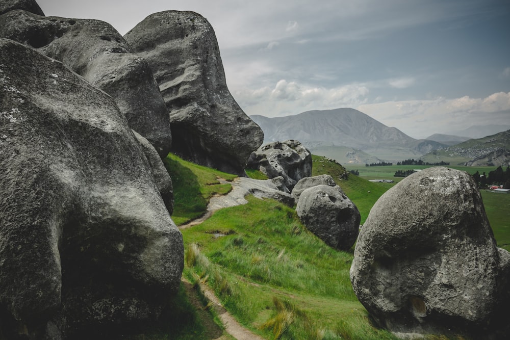 gray rock formation on green grass field during daytime