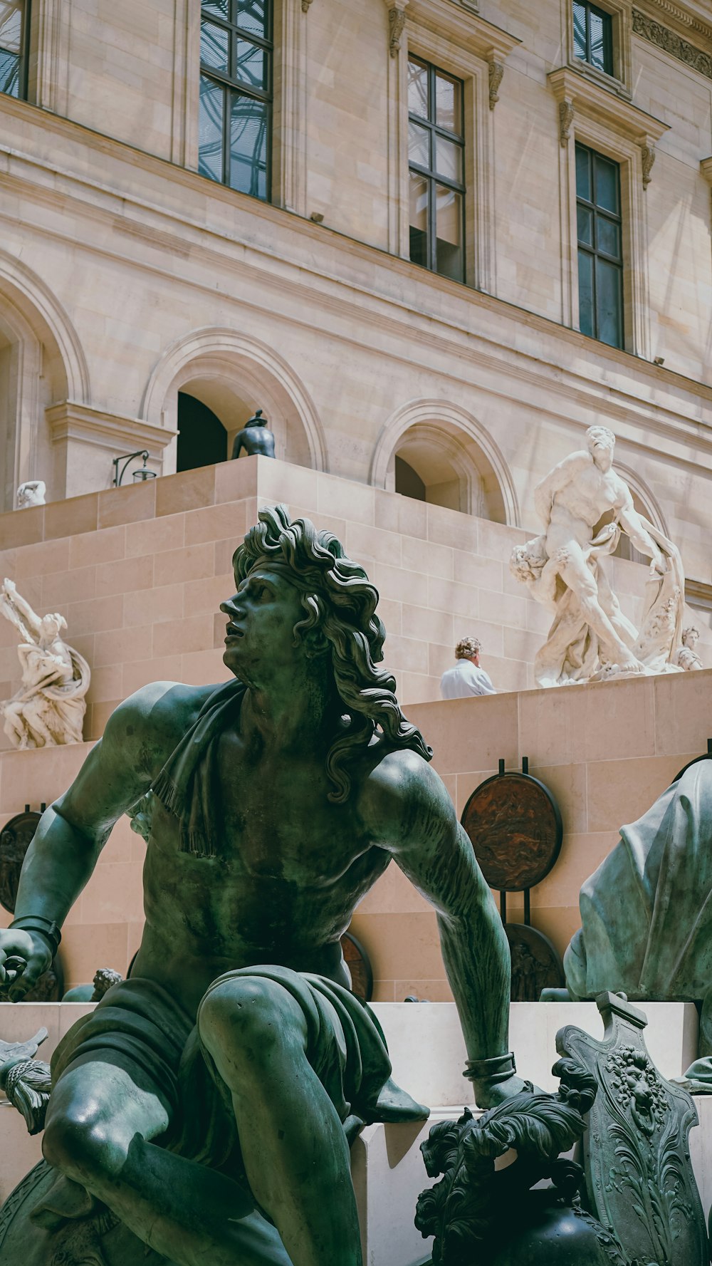 man holding a book statue