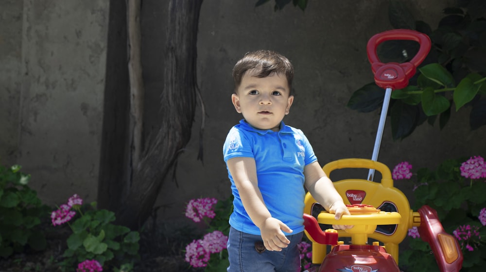 boy in blue crew neck t-shirt and blue denim shorts standing on red and yellow