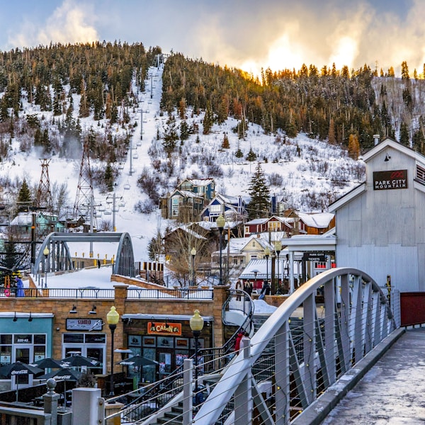 white wooden bridge over snow covered mountain during daytime