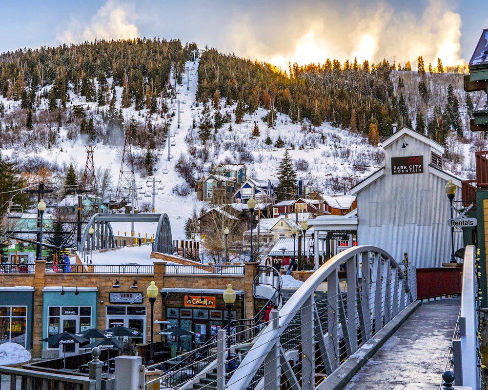 white wooden bridge over snow covered mountain during daytime