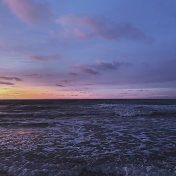 A serene ocean view from the hermitage with gentle waves and a peaceful sky at dusk.