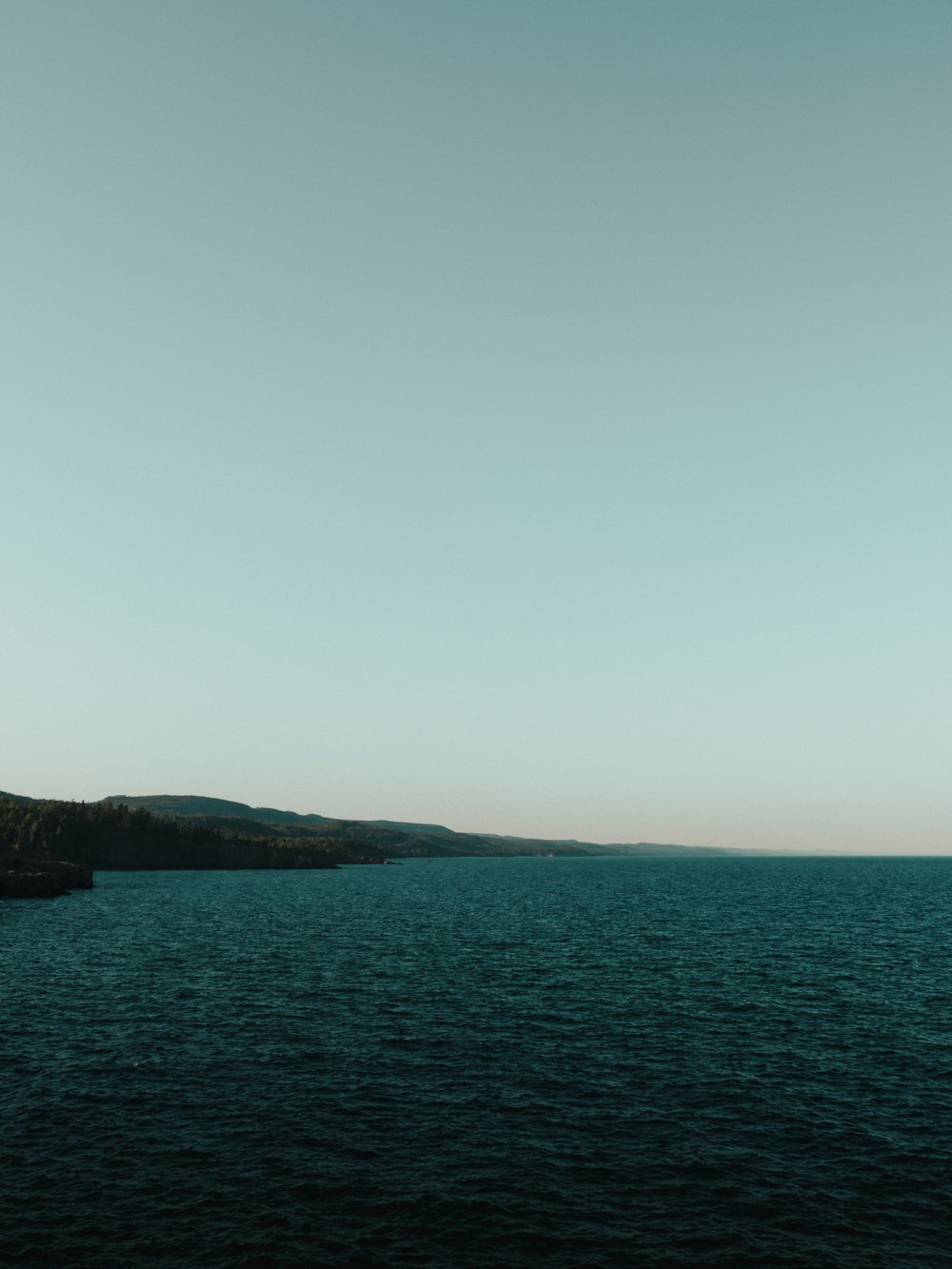 a large body of water sitting under a blue sky