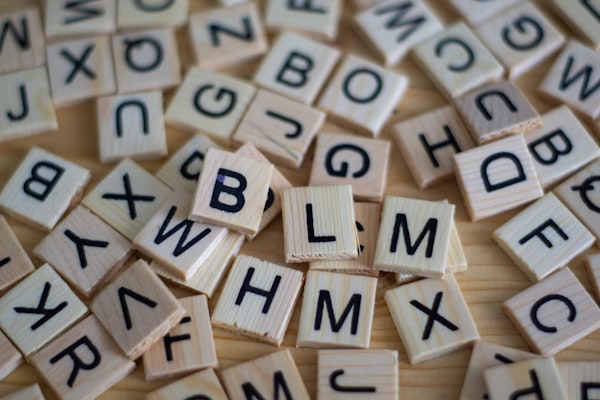 A collection of wooden tiles with letters on them. Possibly from Scrabble.