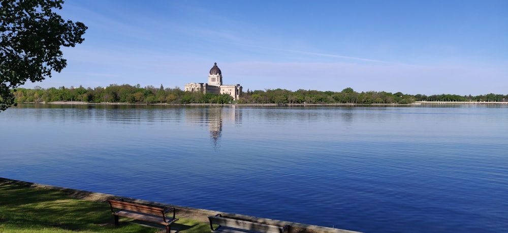 white and brown concrete building near body of water under blue sky during daytime