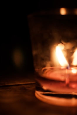 Concrete container with a lit candle inside, highlighting warm ambiance.