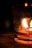 A softly lit living room corner with a Flambeau candle casting gentle shadows.