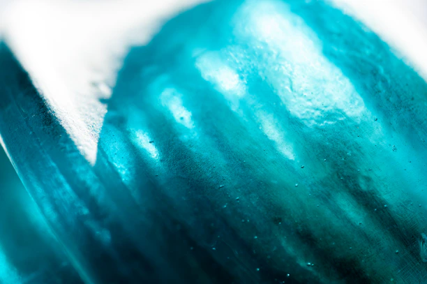 Close-up 3D rendering of a translucent membrane pore structure illuminated with cool teal and cyan highlights.