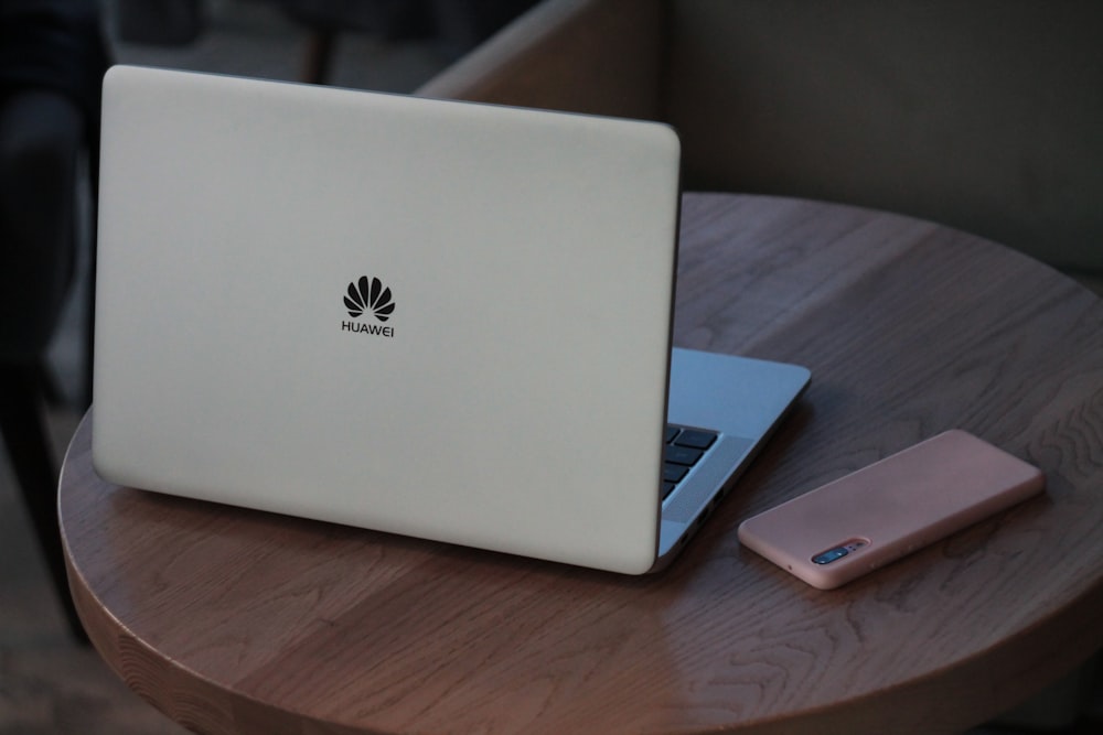 MacBook argentato su tavolo di legno marrone