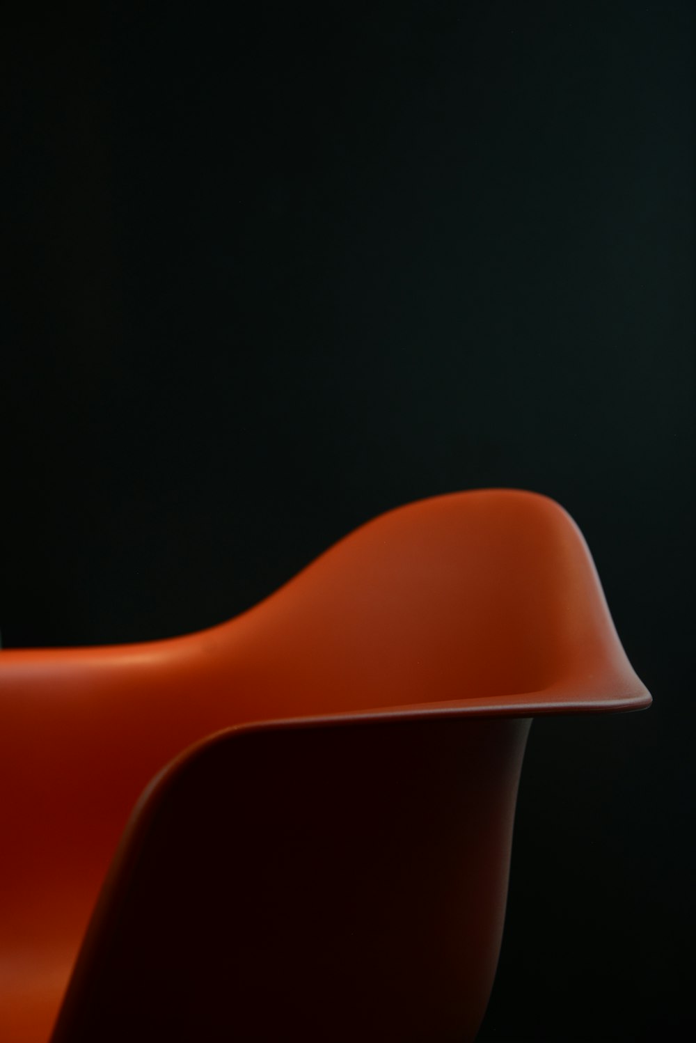 cadeira plástica vermelha no fundo preto
