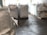Large industrial sacks are positioned in a warehouse with a focus on one sack in the foreground and more sacks blurred in the background. The setting appears to be indoors with soft lighting, creating a sense of a spacious storage facility.
