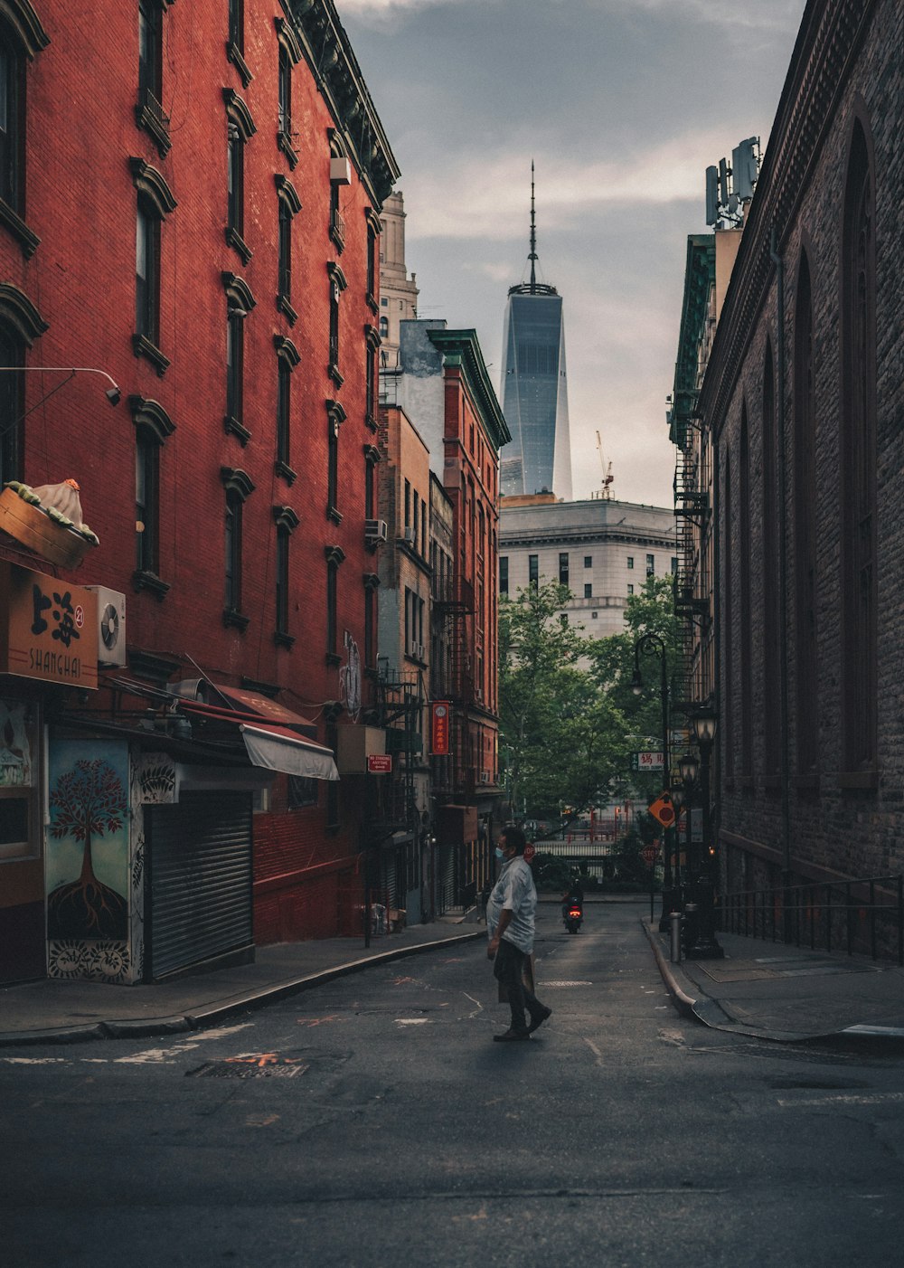 man in black jacket and blue denim jeans walking on sidewalk during daytime