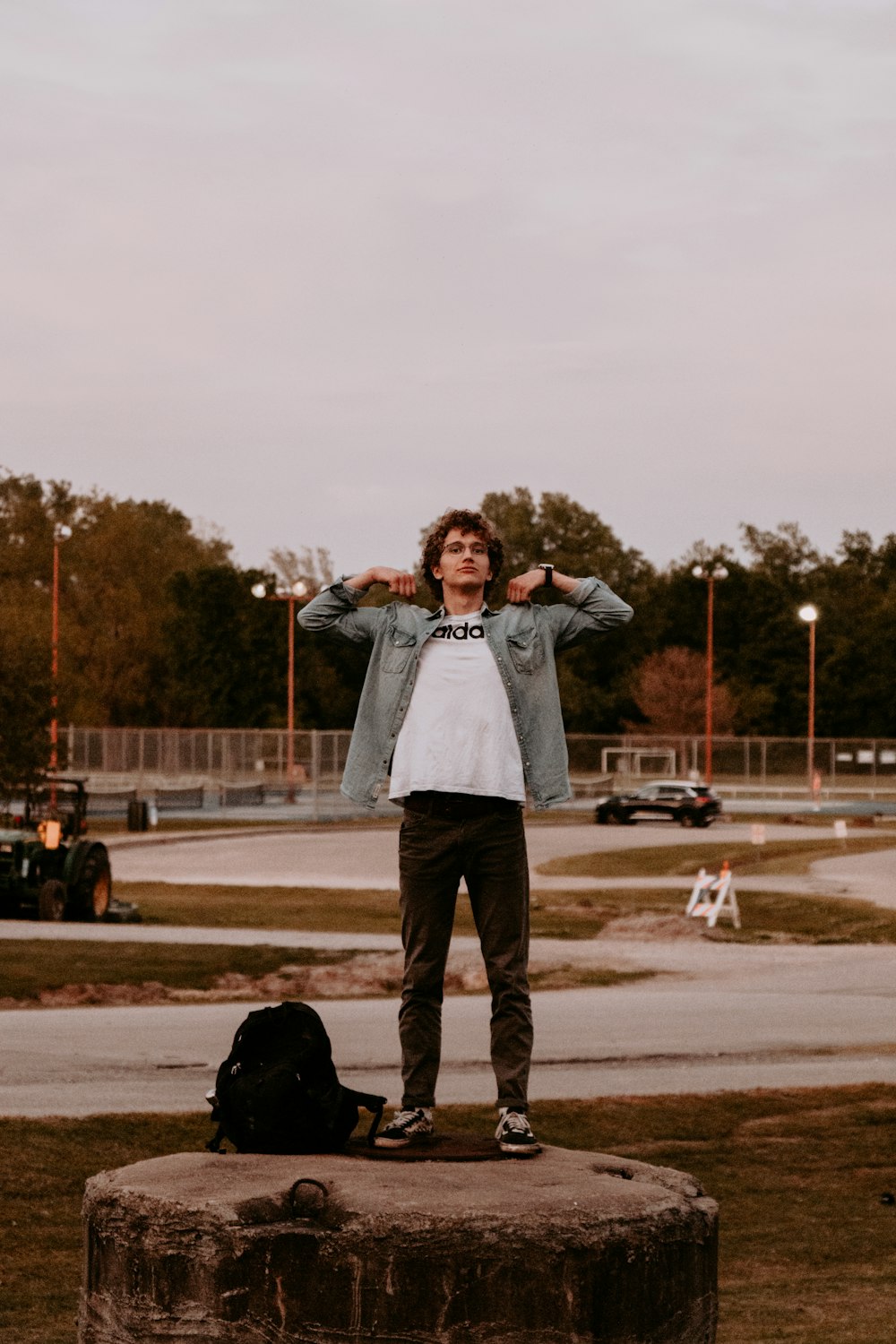 man in white dress shirt and black pants standing on brown field during daytime