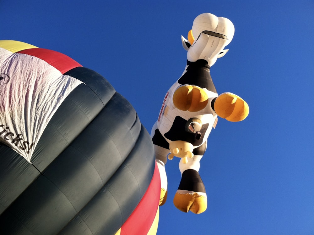 brown and white giraffe plush toy on blue and red hot air balloon during daytime