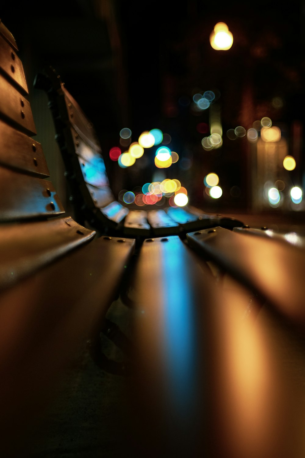 black metal bench in front of lighted city buildings during night time